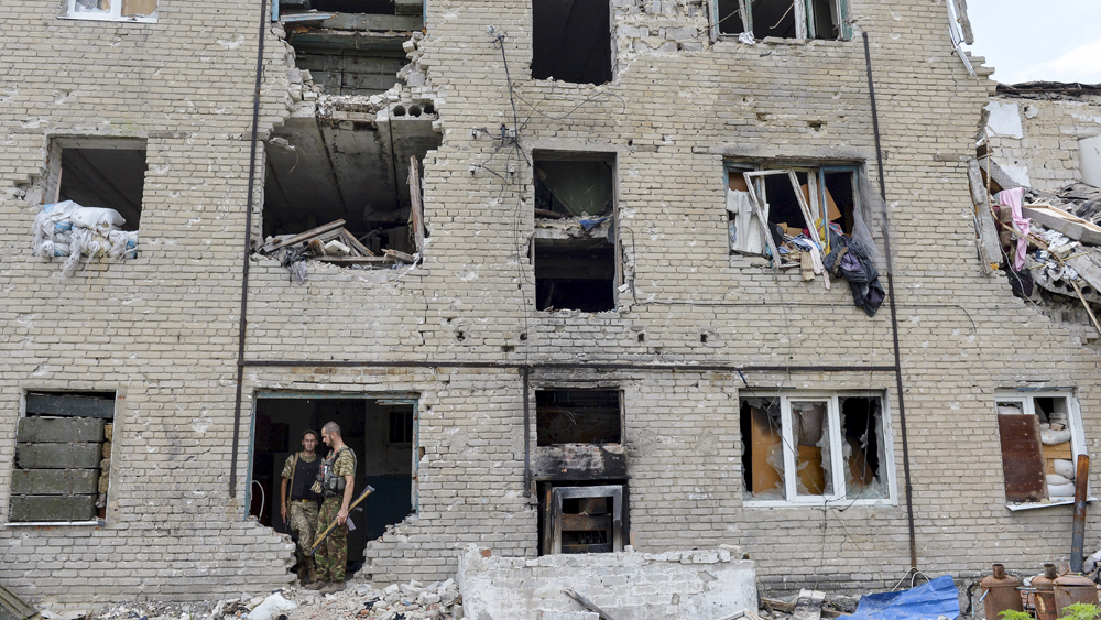 Members of the Ukrainian armed forces stay at a building damaged in fighting with pro-Russian separatists in Pesky village, near Donetsk, Ukraine, July 6, 2015. REUTERS/Oleksandr Klymenko TPX IMAGES OF THE DAY - RTX1J9WJ